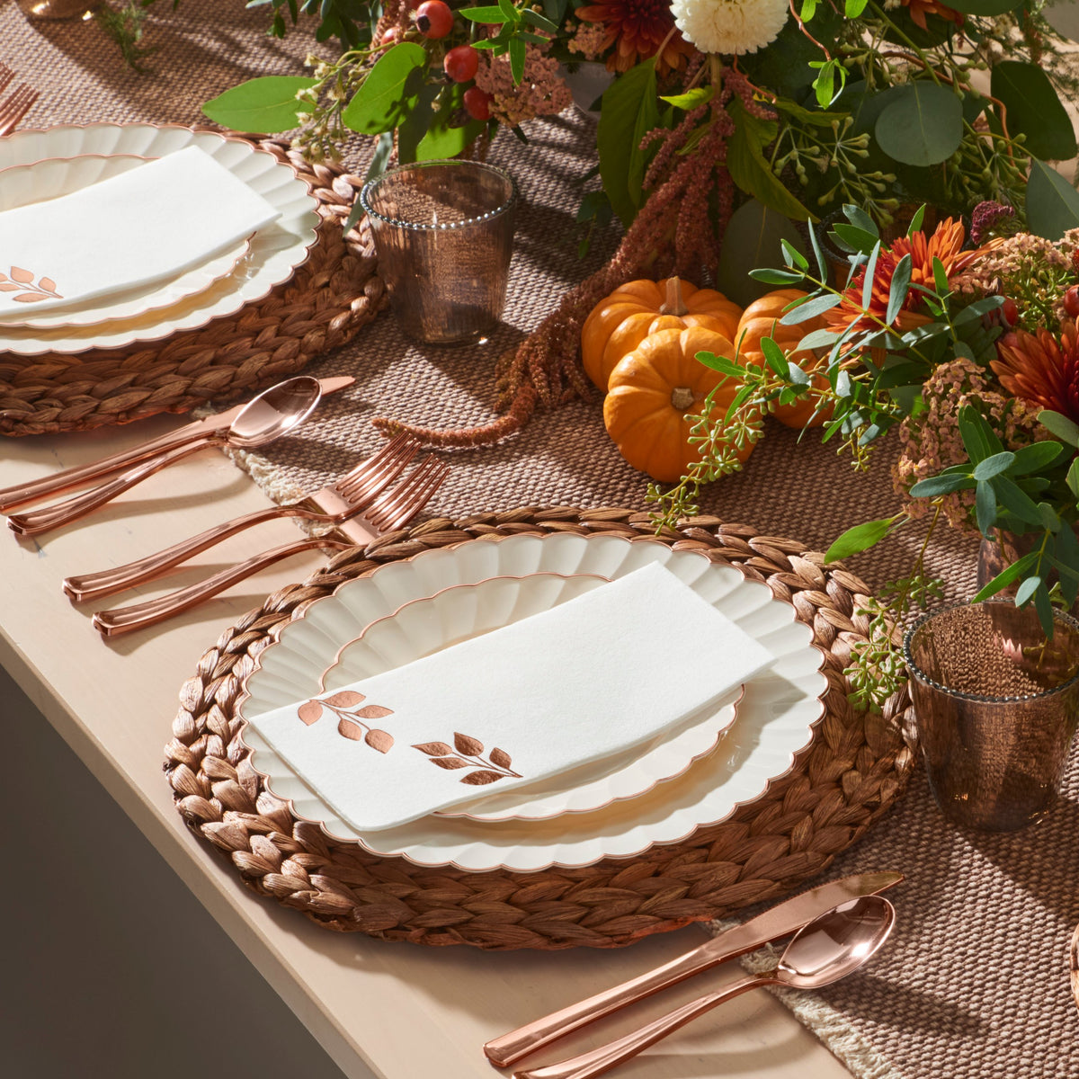 Ivory rose gold scalloped plates styled on a Thanksgiving table with pumpkins
